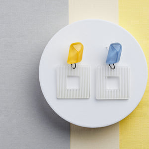 blue and yellow  crystal stones handcrafted earrings on grey and yellow background