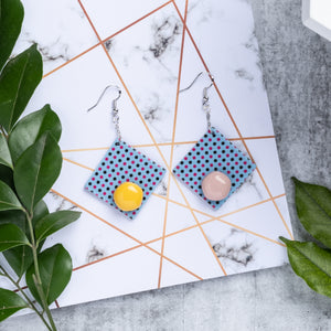 yellow and pink dots with blue square shape handcrafted earrings on marble background