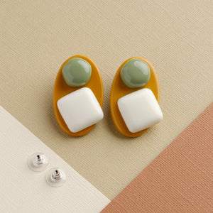 NINI WEAR matcha green and white handmade earrings on light brown background